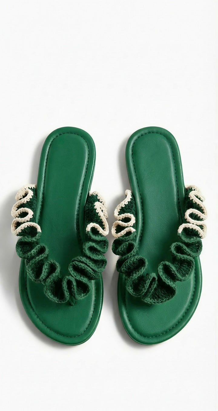 Pair of green sandals with half cream crochet  ruffled straps on a white background