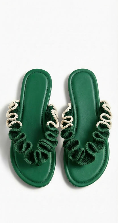 Pair of green sandals with half cream crochet  ruffled straps on a white background