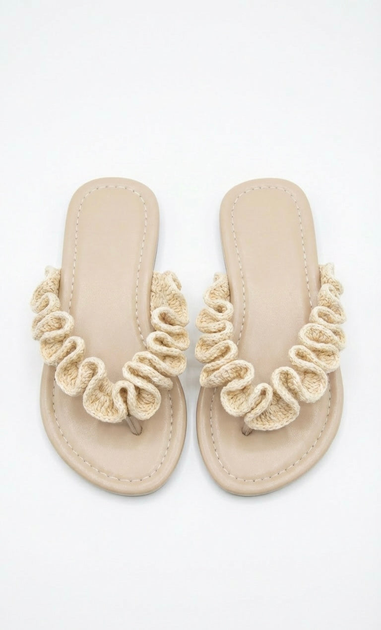 Pair of beige sandals with crochet ruffles on a white background
